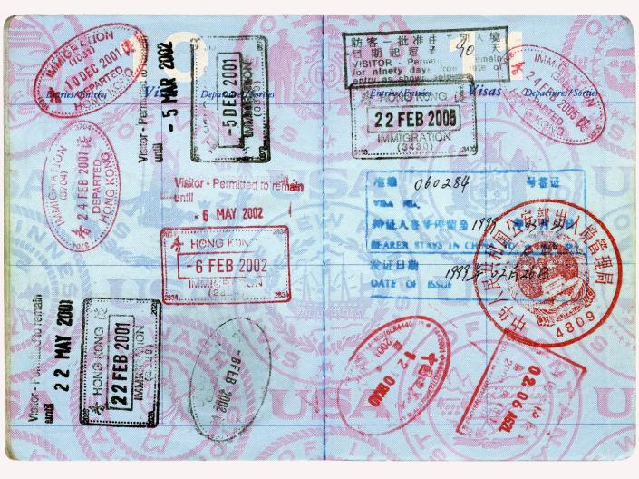 Passport stamps cover a blue passport.