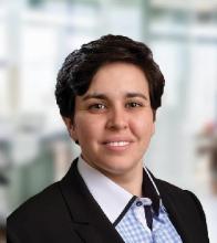 Headshot image of Natalie McVeigh, a woman wearing a black jacket and white dress shirt