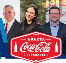 ABARTA Coca Cola; people standing behind logo