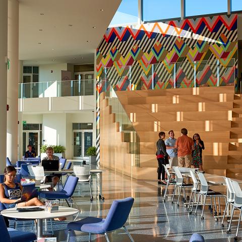 Interior image of the Tinkham Veale University Center with a group of people standing at the base of the stairs