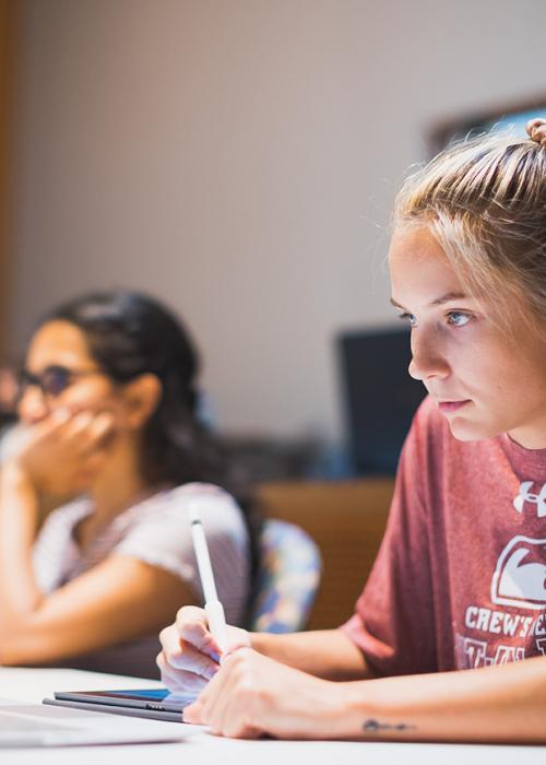 A student in class taking notes