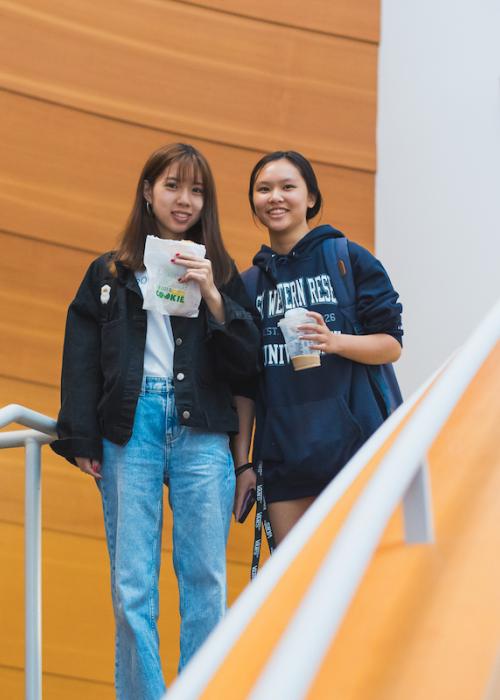 Two Weatherhead students of color pose together at the top of a staircase in the Peter B. Lewis Building