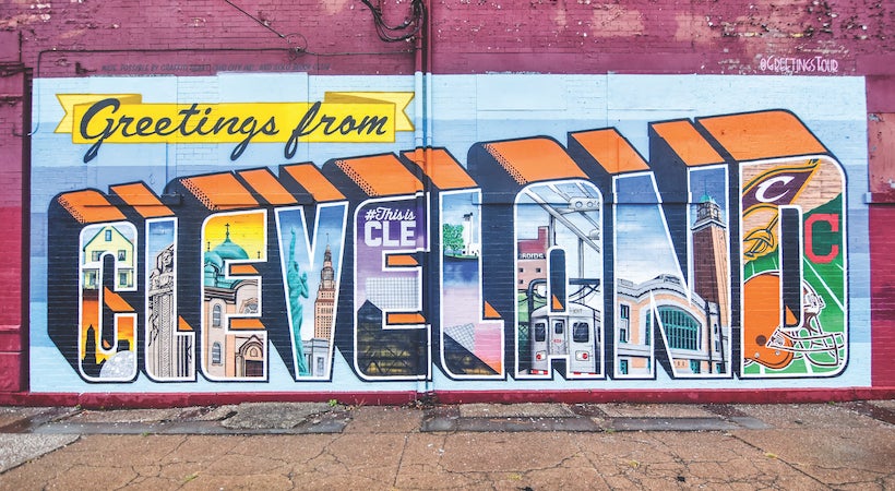 Mural on a brick wall that reads "Greetings from Cleveland"