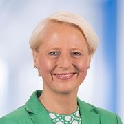 Headshot image of Liz Ahmed, a woman with blonde hair wearing a green shirt