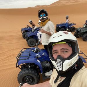 Photo of Joaquin Mendoza posing with ATVs in the Sahara Desert
