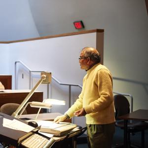 A faculty member points to screen while giving lecture