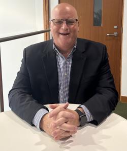 Brian Breittholz smiles while sitting at a table.