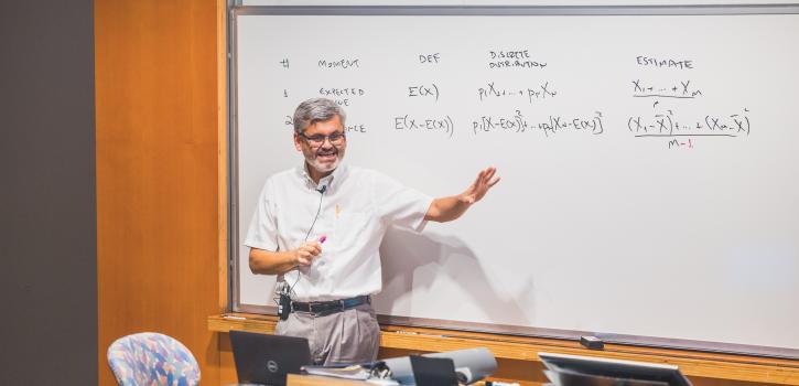 A faculty member using a whiteboard while teaching