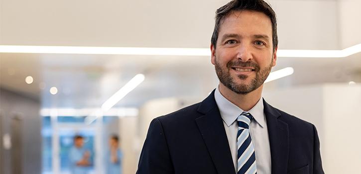 man in a suit smiling in a hallway