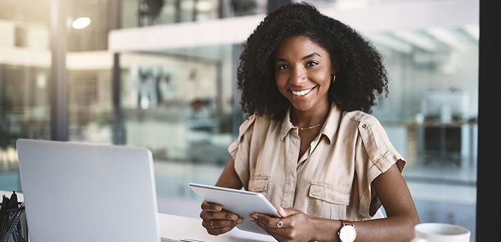 professional woman smiling with laptop in front of her