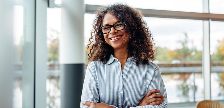 woman in glasses smiling with arms crossed