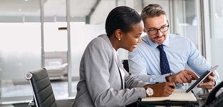 man and woman looking at a tablet together