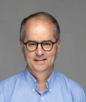 Headshot image of Mark Schweitzer, a man wearing a light blue shirt
