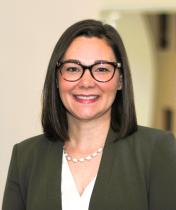 Headshot image of Melissa Carlisle, a woman wearing glasses, a green/gray blazer and white blouse