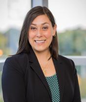 Headshot image of Nicole Tischler, who is wearing a black jacket over a green blouse