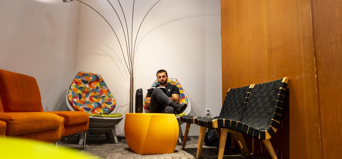 Student sitting in a chair in a colorful space