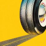 A tire leaving a track on the ground against a yellow background