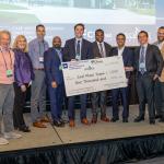 A group photo of entrepreneurship students being awarded a check on stage