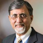 Headshot image of Asok Chaudhuri, a man in a dark suit with glasses and a white goatee