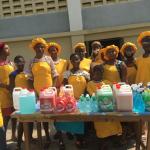 An image of a group of girls standing behind a table.