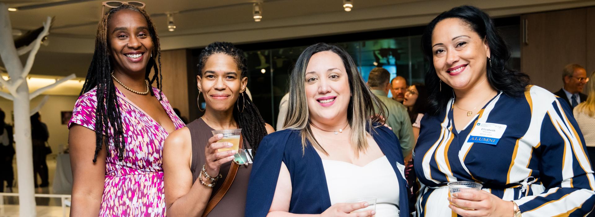 Group of four women posing at a Weatherhead alumni gathering