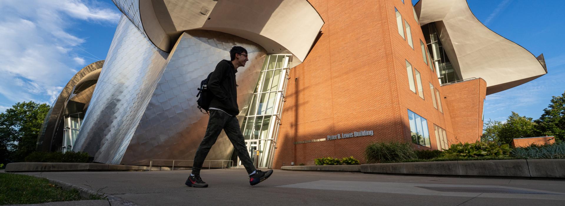 Exterior of the Peter B. Lewis Building with a student walking in front of it