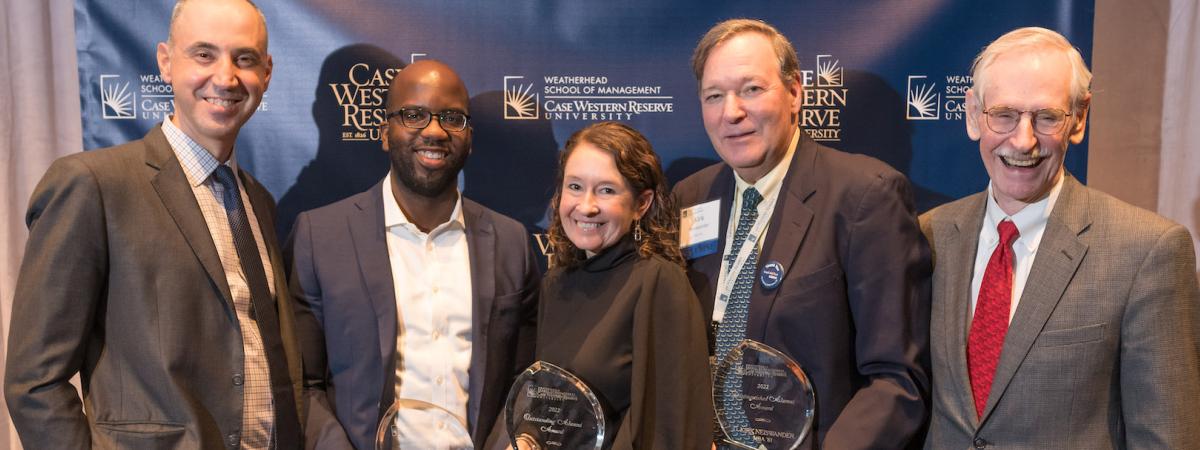 Photo of Weatherhead School co-deans posing with three alumni with awards