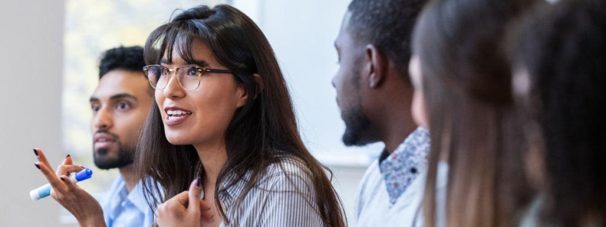 Female student talking while surrounded by other students