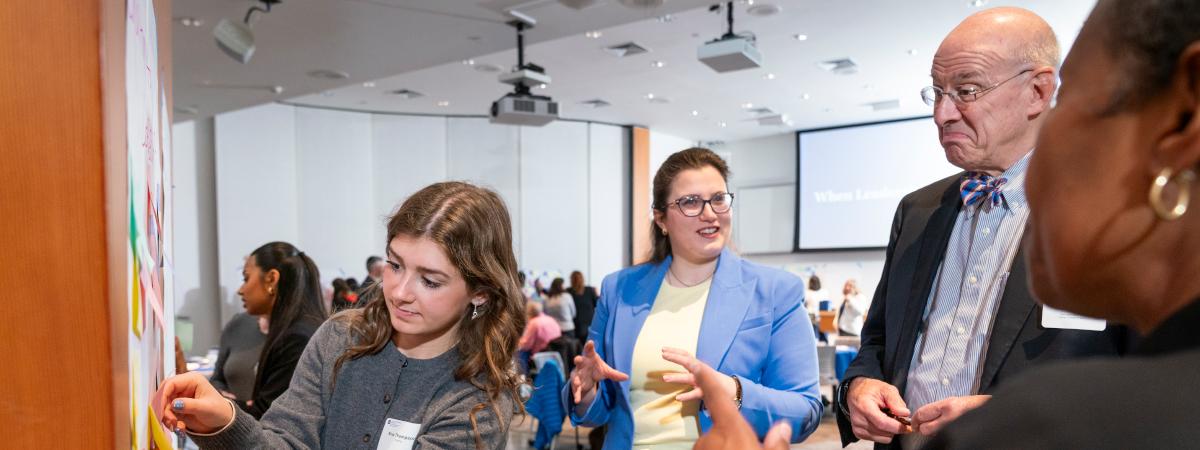 A group of people talking during an event in a conference room.