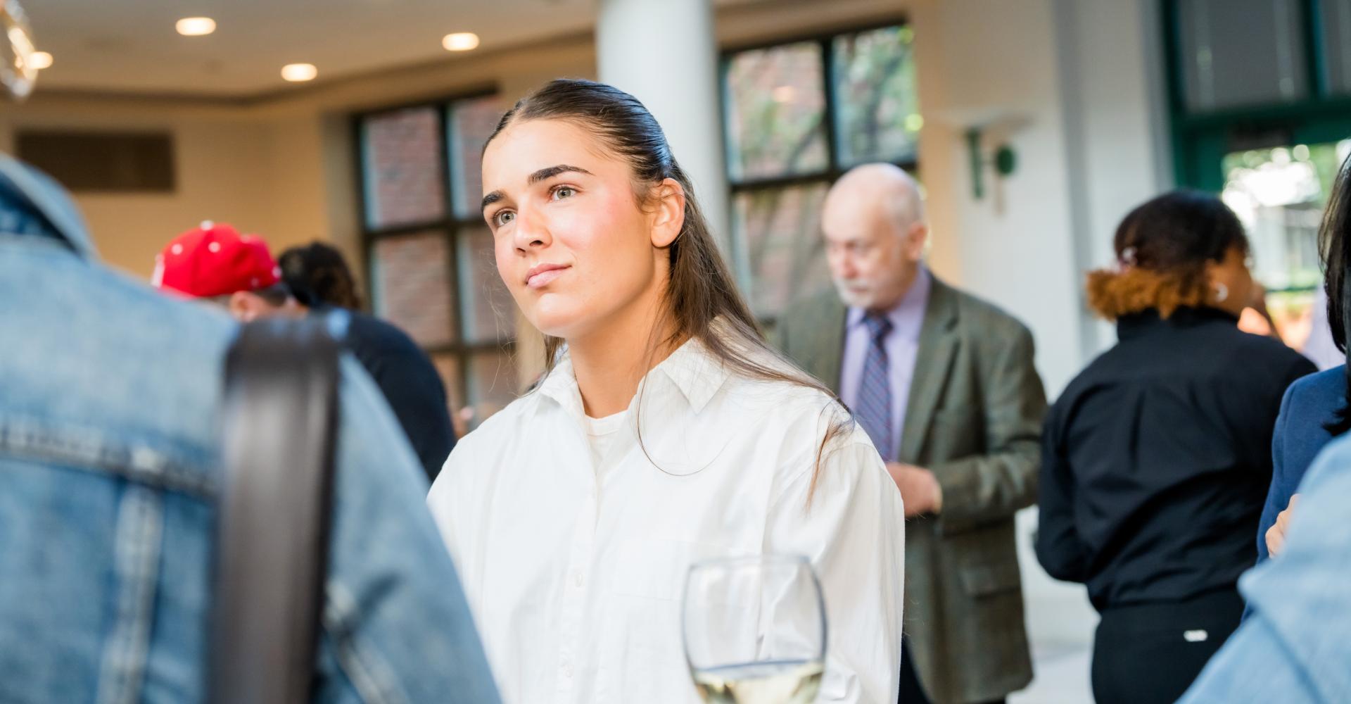 Female student listening to another person at a gathering