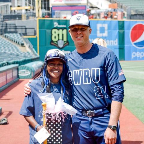 Bianca Smith poses with a CWRU baseball player in a stadium 