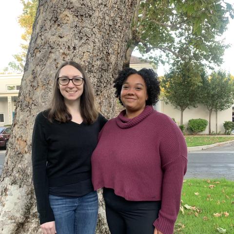 Picture of Beth Magid and Jahlyn Reyes-McKinley posing together in front of a large tree
