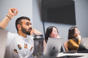 Weatherhead student in class raising his hand to ask a question