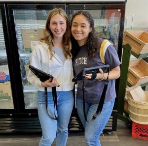 Beyah-Vida Garcia smiles next to a fellow student while volunteering at Midtown Market