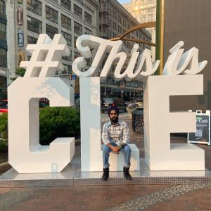 Jaspal Singh Juneja sits on the #This is CLE sign in downtown Cleveland