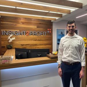 Solomon Goldstein smiles standing in front of the Insight2Profit front desk.