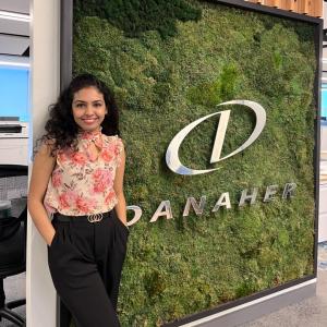 Pranita Chaudhari smiles in front of a Danaher Corporation sign