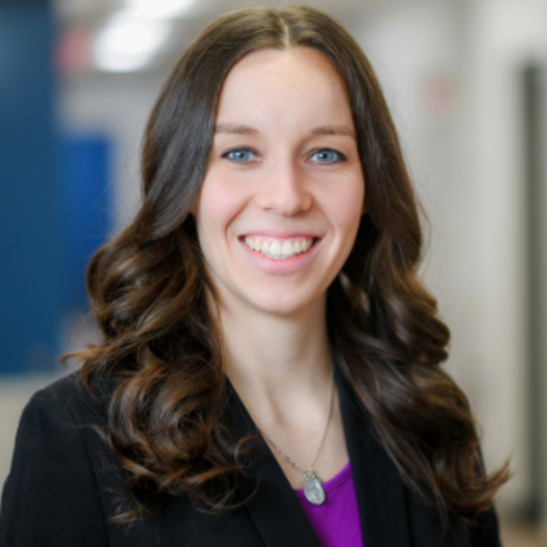 Erin Gdaniec smiles in a black suit.