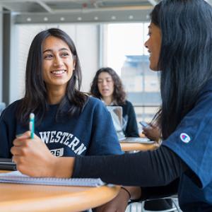 two girls laughing across a table
