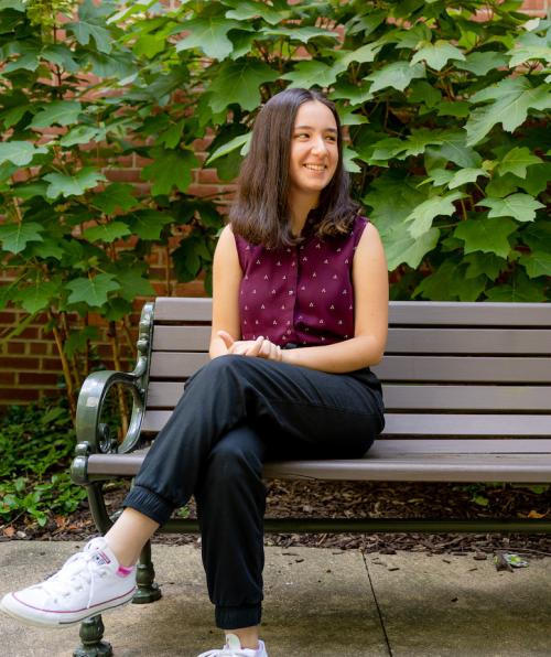 Annual Giving student Johana Gucci poses on a bench on campus.