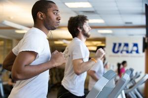 Men on a treadmill running.