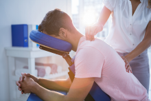 a mean sitting in a chair getting a back massage