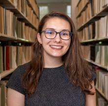 Photo of Mandee Young in front of bookshelves