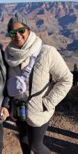 Photo of Saral Patel, dressed in warm clothing with canyons in the background