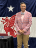 Jason Steckel in a suit jacket standing in front of a flag