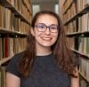 Photo of Mandee Young in front of bookshelves