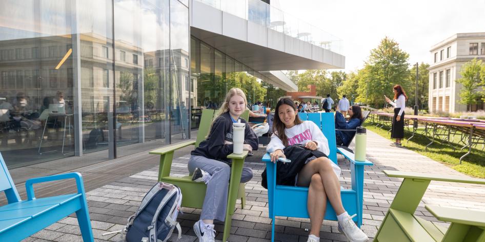 Students sitting outside the university center in warm weather.