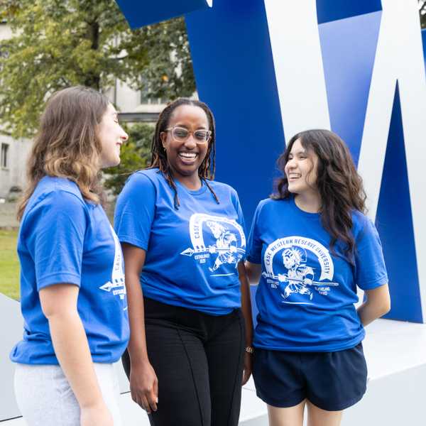 A group of three students smiling and posing in new blue CWRU t-shirts.